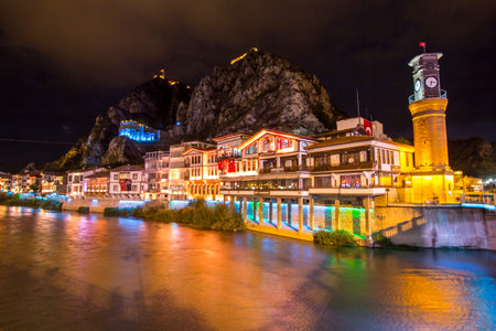 Old Ottoman houses and Clock Tower with night colorful light and mirrored view by the Yesilirmak River in Amasya. Amasya is a popular tourist destination in Turkey.の写真素材