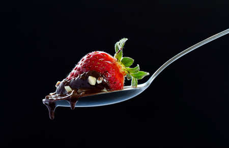 strawberry with chocolate on spoonの写真素材