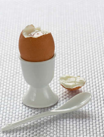 A boiled egg in cup with spoon  for breakfastの写真素材