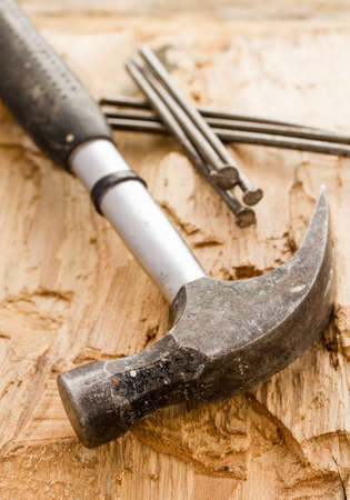 Vintage hammer with nails on wood background 