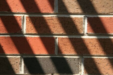 Angled shadows on a brickwallの写真素材