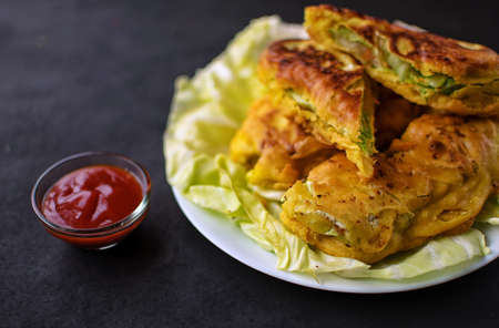 Vegetable Spring Roll with spicy tomato sauce dip garnished with fresh cabbage leaves a classic Indo Chinese dish perfect for evening snacks or entertaining guestsの写真素材
