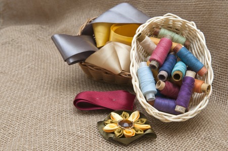 Handicraft supplies in basket on burlap background
