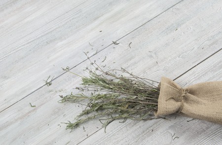 Dried lavender bunch in the small sack on the wooden table. Template for advertising.