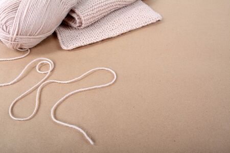 Hobby. Knitting. A skein of wool and a knitted scarf of beige thread.の写真素材