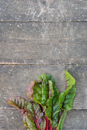 Fresh beetroot leaves chard on the surface of an old wooden table