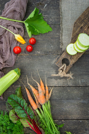 Fresh vegetables with leaves on the old wooden cutting board. Rustic styleの写真素材
