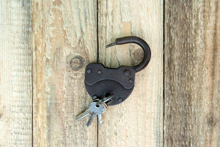 Opened old rusty lock with several keys lying near. Copy space. Looking for problem solution concept...