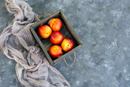 Fruits of nectarines peaches in a wooden box. Rustic style. Copy space.の写真素材