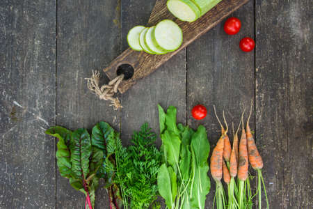 Fresh vegetables with leaves on the old wooden cutting board. Rustic styleの写真素材