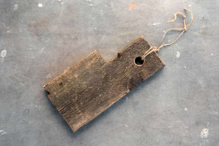 Brown wooden kitchen cutting board in rustic style against the background of gray ancient fabric