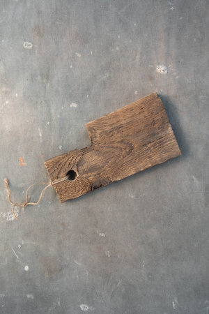 Brown wooden kitchen cutting board in rustic style against the background of gray ancient fabricの写真素材
