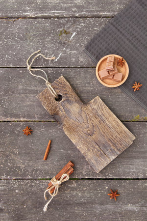 Pieces of chocolate, cinnamon sticks and star anise on a wooden board, photo rustic style. Copy spaceの写真素材