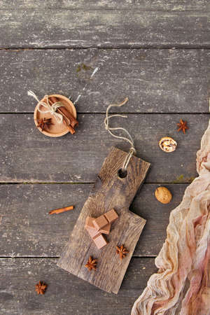 Pieces of chocolate, cinnamon sticks and star anise on a wooden board, photo rustic style. Copy spaceの写真素材