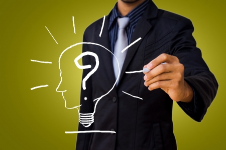 Drawing a question mark in the head lamp by businessman  の写真素材