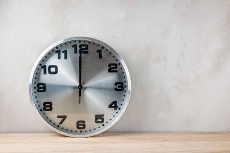 The silver clock tells the time at noon.の写真素材