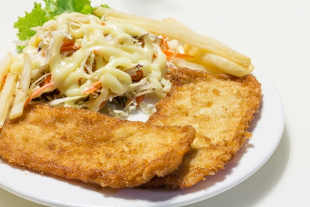 home made fish chip with salad on white dishの写真素材
