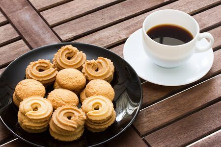 cookies with black coffee on wood tableの写真素材
