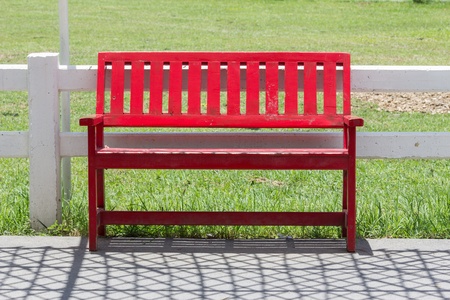 red bench on the road in the gardenの写真素材