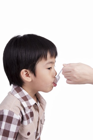 boy feeding medicine with a spoonの写真素材