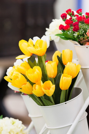 artificial yellow tulips in white potの写真素材
