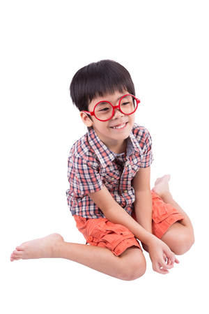 cute little boy sitting and smiling, isolated on white backgroundの写真素材