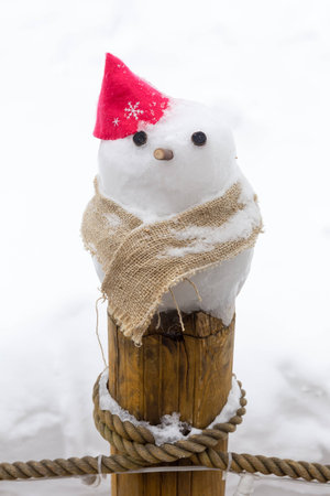 little snowman on wooden poleの写真素材