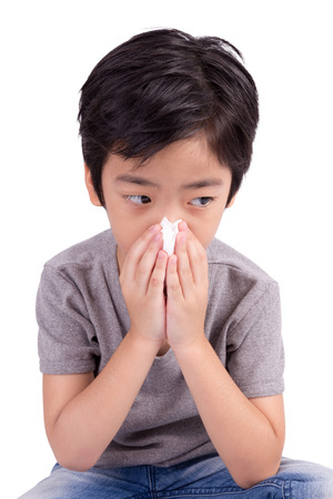 kid cleaning nose with tissue isolated on whiteの写真素材
