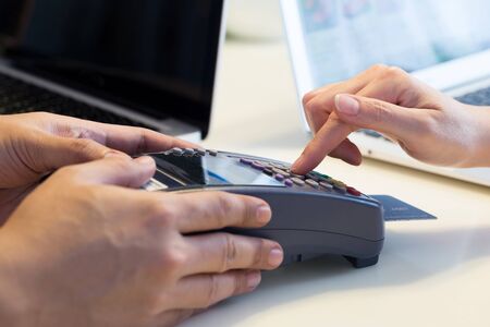 woman swipes her credit card to make the payment