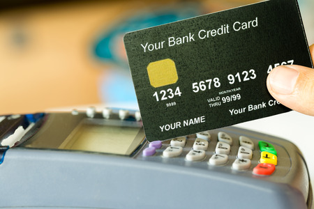 hand holding a credit card with credit card machineの写真素材