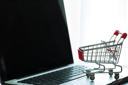 Mini Red Shopping Cart On Laptop : Online Shopping Conceptの写真素材
