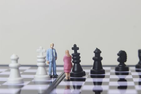 Simple illustration for photo War, Battle or politic situation concept, 2 standing mini figure, man and woman negoitation or debate beyond Small Magnetic Plastic chessの写真素材