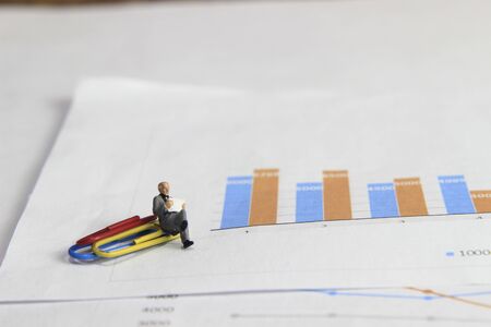 Simple Illustration Photo 1 Sitting old man Toy Reading Graphic Business Chart at colorful paperclipの写真素材