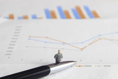 Simple Illustration Photo 1 Sitting Mini Figure old man Toy Reading Graphic Business Chart at Black and stainless steel penの写真素材
