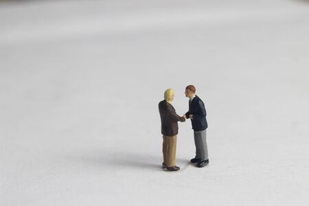 Gray Backgrond, Simple Illustration Photo for Mini Figure Two Man Toy Handshaking for Business Agreementの写真素材
