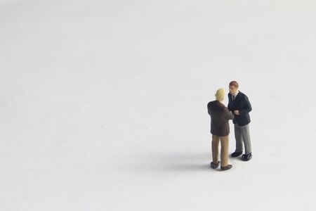 Gray Backgrond, Simple Illustration Photo for Mini Figure Two Man Toy Handshaking for Business Agreementの写真素材