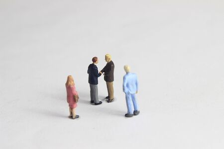 Gray Backgrond, Simple Illustration Photo for Mini Figure Two Man Toy Handshaking for Business Agreement Beyond their partnerの写真素材