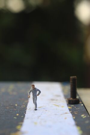 Illustration Photo, Cheap and Easy Sport in the morning, Alone Mini Figure Sport Man Toy at Asphalt Roadの写真素材
