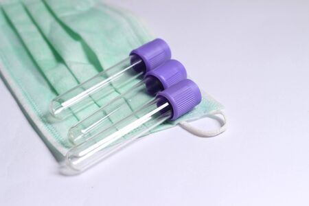 Close Up Photo, Simple Conceptual, Empty Glass Blood Covid-19 Test tube, without label, above N95 Surgical Maskの写真素材