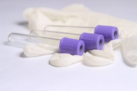 Close Up Photo, Simple Conceptual, Empty, without Label Glass Blood Covid-19 Test tube, positive result, above White Rubber Gloveの写真素材