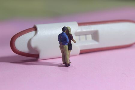 illustation photo for Lovely moment, Young Couple Mini figure Toy kissing beyond Pregnancy test pack...