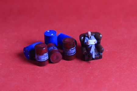 Photo Close Up, Scale HO Sitting old Businessman Beyond Red and Blue Oil Barrel, for your element...