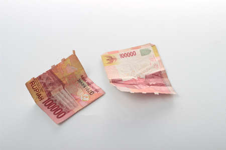 Conceptual Photo Rupiah Paper Money, Torn or Broken 100000, Top View at White Background