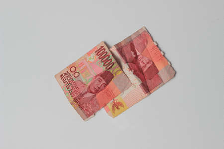 Conceptual Photo Rupiah Paper Money, Torn or Broken 100000, Flat Lay at White Background