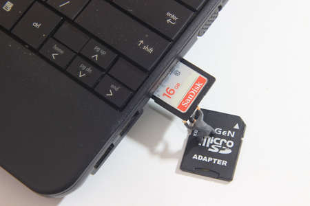 Editorial Conceptual Close Up Photo, DKI Jakarta Indonesia, 24 November 2021, Worker inserting Sandisk 16 GB SD Card into Notebook Slotのeditorial素材