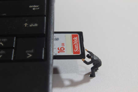 Editorial Conceptual Close Up Photo, DKI Jakarta Indonesia, 24 November 2021, Worker inserting Sandisk 16 GB SD Card into Notebook Slotのeditorial素材