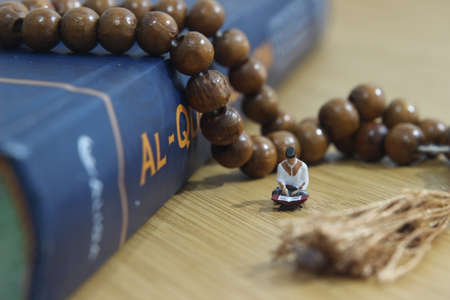 Simple Conceptual Photo, Islam Man or Muslim, Read Al Quran, Al Qur'an Near The Real One and Wooden Prayer Beadの写真素材
