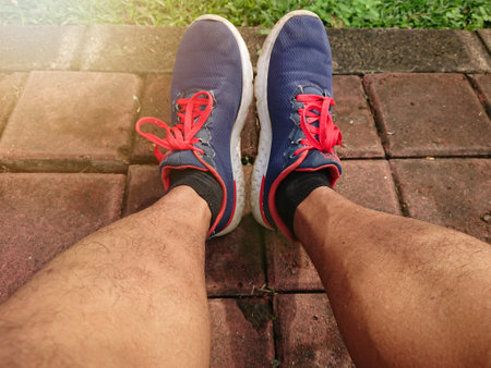 Close up, Big Man Leg Using Blue Sport Shoes, with lens or sun shine flareの写真素材