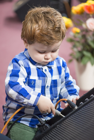 Little boy putting a cable into a speakerの写真素材