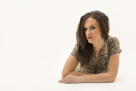 portrait of a beautiful lady lying down on her belly isolatedの写真素材